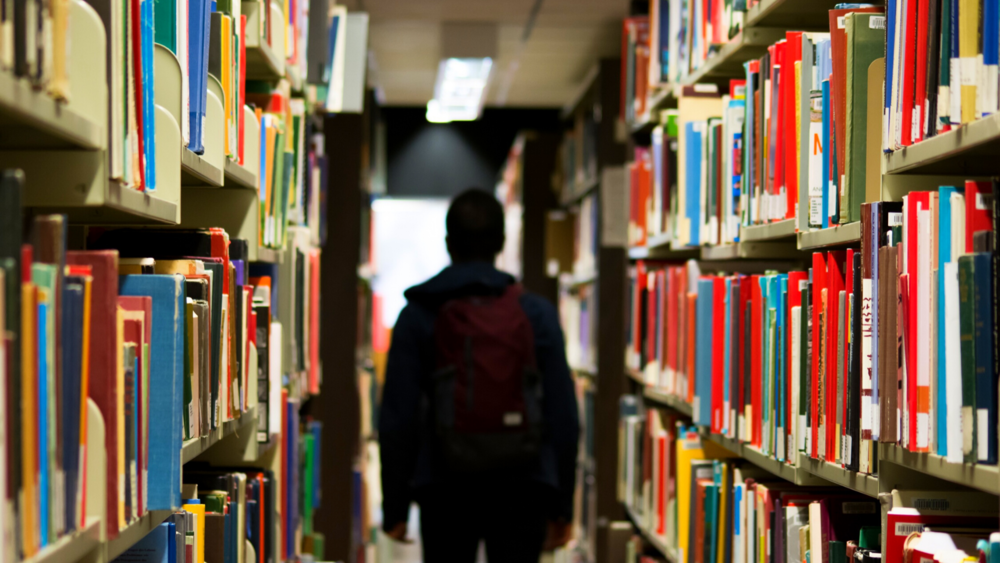 A student walks through a library.