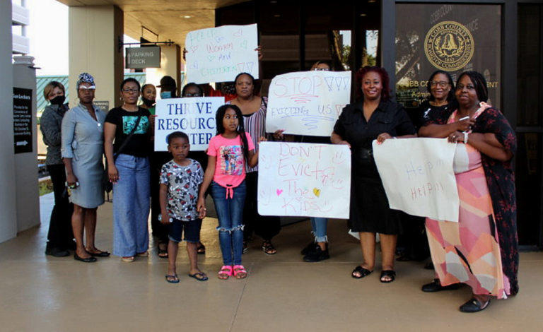 Cobb County residents protest with signs outside of the Cobb County Board of Commissioners meeting on June 22, 2021. 