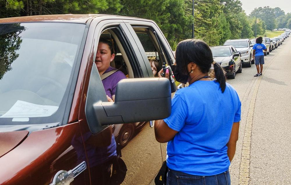 Cars travel to a back to school event the Friday before the new school year in Macon. 