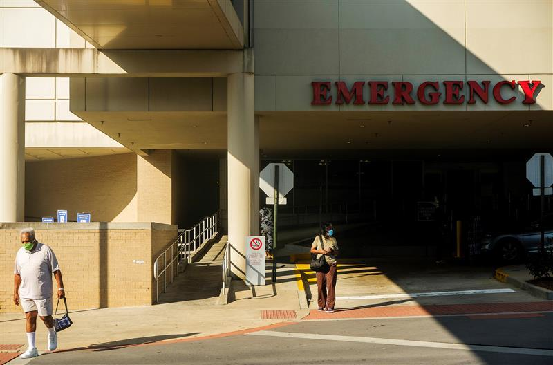 two masked people outside a hospital emergency room