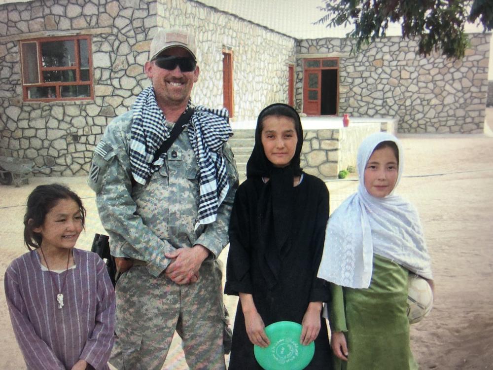 Sgt. Timothy Turner posing with girls from an Afghan orphanage.