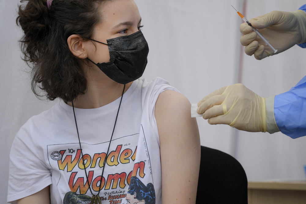 A girl gets a Pfizer BioNTech COVID-19 vaccine 