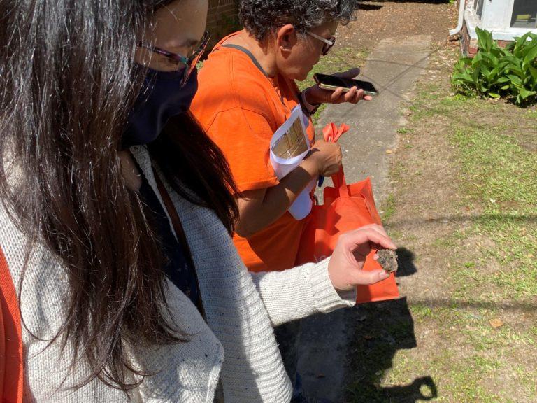 Saikawa holds a piece of slag with area resident Rosario Hernandez alongside her.