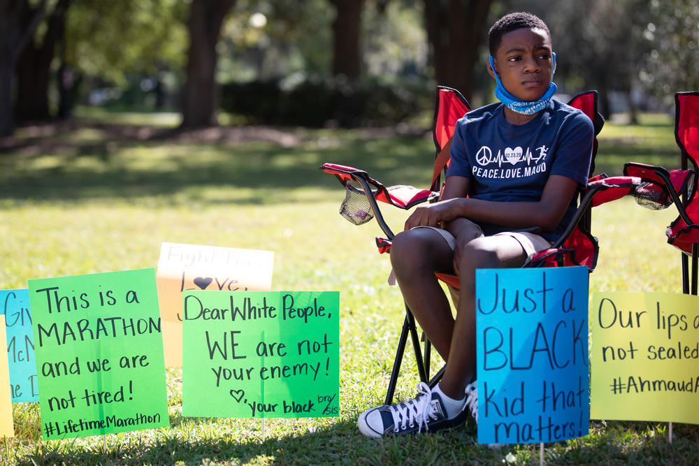 A young boy joins rally goers outside Glynn County Courthouse