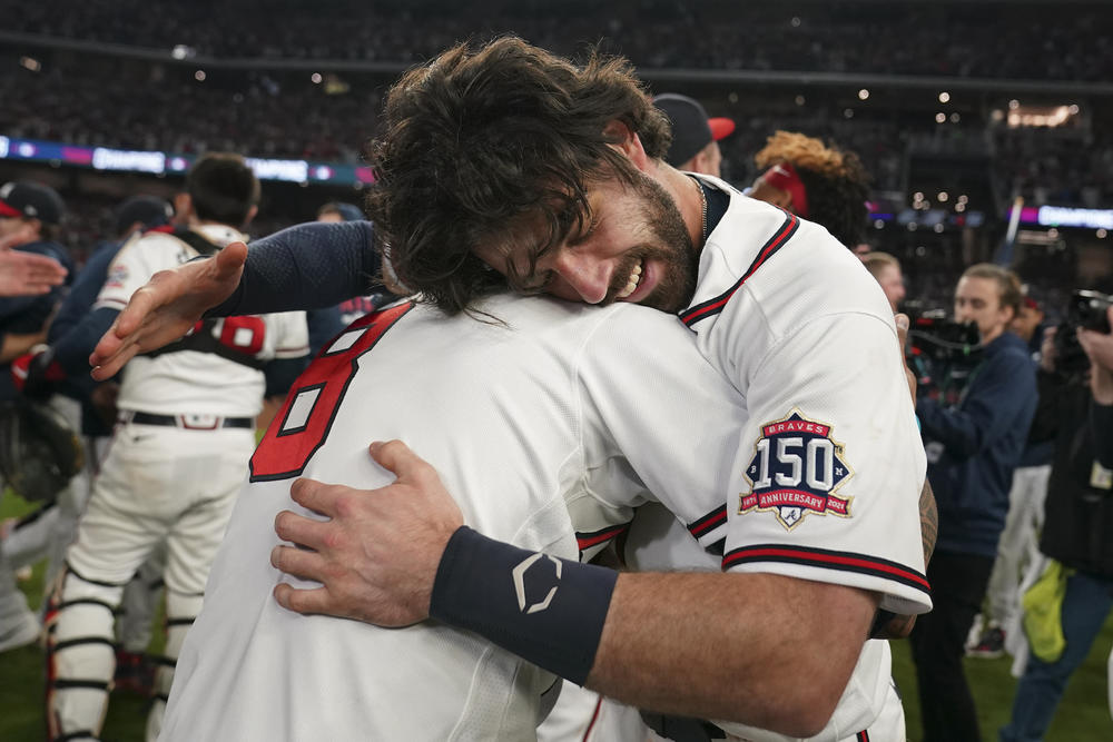 Atlanta Braves shortstop Dansby Swanson, right, hugs Atlanta Braves' Eddie Rosario after winning Game 6 of baseball's National League Championship Series against the Los Angeles Dodgers Sunday, Oct. 24, 2021, in Atlanta. The Braves defeated the Dodgers 4-2 to win the series.