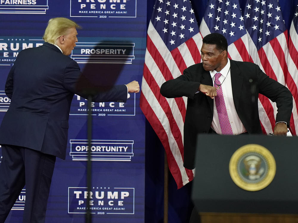 In this Sept. 25, 2020, file photo, President Donald Trump elbow bumps with Herschel Walker during a campaign rally in Atlanta.