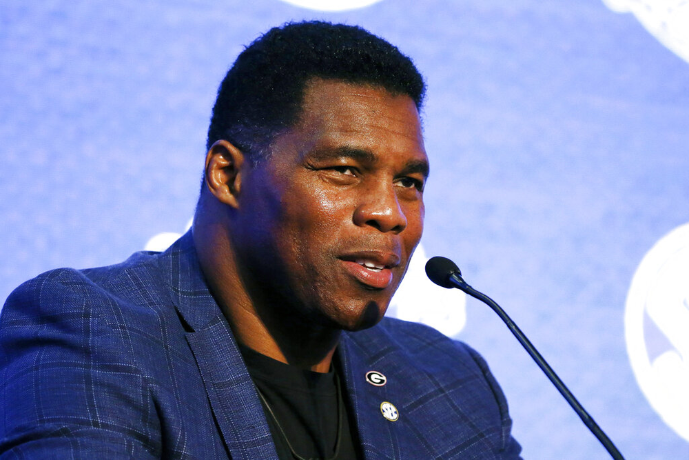 A photo of Herschel Walker speaking at a college sports event.