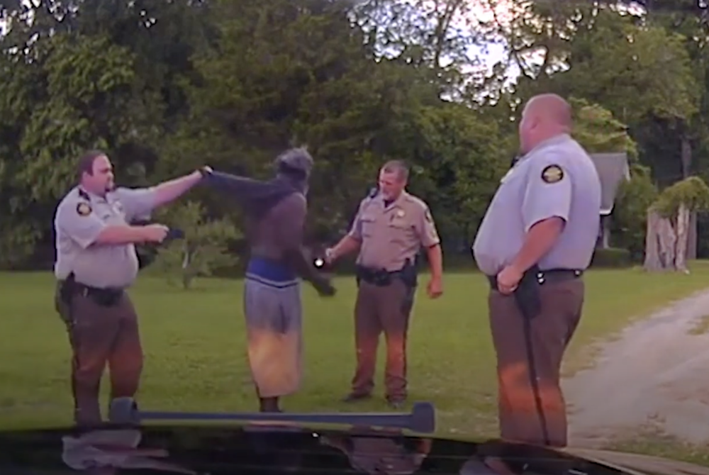 Rhett Scott, left, lifts Eurie Martin's shirt in order to get skin only taser contact as Henry Lee Copeland, center right, and Michael Howell talk to Martin during the 2017 encounter where Martin died. 