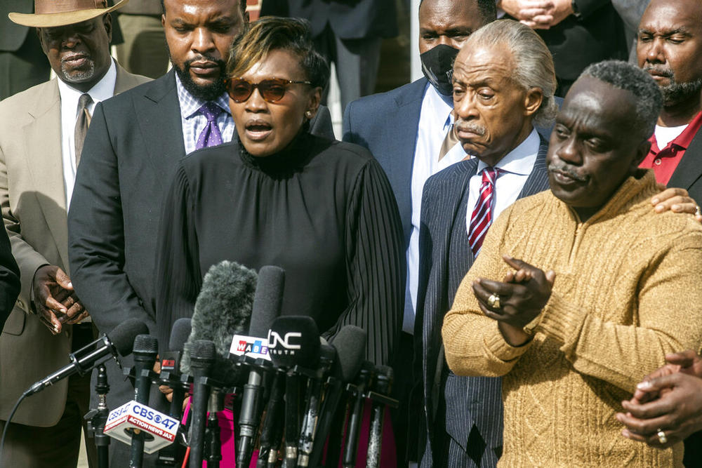 Marcus Arbery, right, applauds as his former wife Wanda Cooper speaks about the slaying of their son Ahmaud Arbery as Civil rights leader Rev. Al Sharpton stands between them outside the Glynn County courthouse, Wednesday, Nov. 10, 2021, in Brunswick, Ga. Rev. Sharpton led a prayer and spoke out against injustice during the noon break in the trial of three men charged with murder in Ahmaud Arbery's shooting death. 