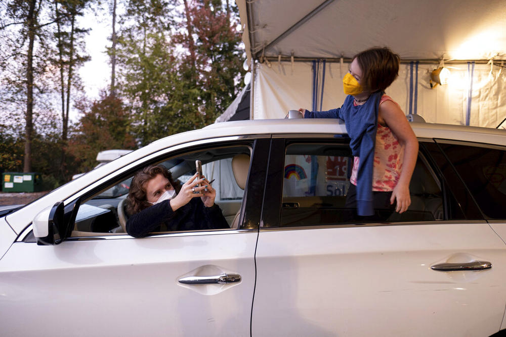 An excited Cate Zeigler-Amon, 10, hangs out of the car as she waits with her mom, Sara Zeigler, to receive her first dose of COVID-19 vaccine at the Viral Solutions vaccination and testing site in Decatur, Ga. on the first day COVID-19 vaccinations were available for children from 5 to 12 on Wednesday, Nov. 3, 2021. The pair arrived one and a half hours before the site opened to be first in line.