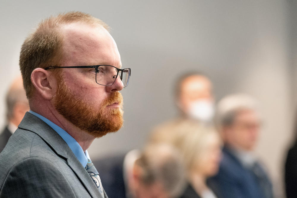 Defendant Travis McMichael stands as the jury enters the room at the Glynn County Courthouse on November 8, 2021 in Brunswick, Georgia.