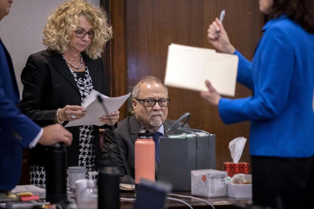 Greg McMichael, center, sits with his attorney Laura Hogue, left, before the start of his trial in the Glynn County Courthouse, Tuesday, Nov. 9, 2021, in Brunswick, Ga.