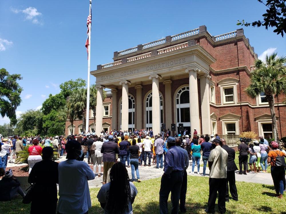 The media spotlight has been trained intensely on the small coastal Georgia town. In this May 2020 photo, crowds gathered on the lawn of the Glynn County courthouse as a grand jury considered murder indictments.
