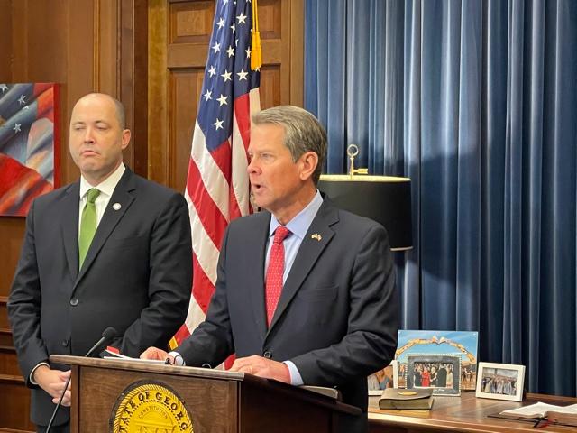 Gov. Brian Kemp speaks as Attorney General Chris Carr looks on.