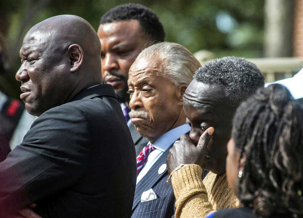 Ahmaud Arbery's father, Marcus Arbery, right, wipes his eyes alongside the Rev. Al Sharpton center, as Benjamin Crump, left, one the family's lawyers speaks outside the Glynn County courthouse, Wednesday, Nov. 10, 2021, in Brunswick, Ga. Rev. Sharpton led a prayer and spoke out against injustice during the noon break in the trial of three men charged with murder in Ahmaud Abery's shooting death.