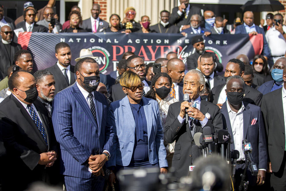 The Rev. Al Sharpton, second from right, flanked by Ahmaud Arbery's parents, Wanda Cooper-Jones, left, and Marcus Arbery, right, speaks to over nearly 750 pastors, supporters and family of Ahmaud Arbery gathered outside the Glynn County Courthouse during a Wall of Prayer event, Thursday, Nov. 18, 2021, in Brunswick, Ga.