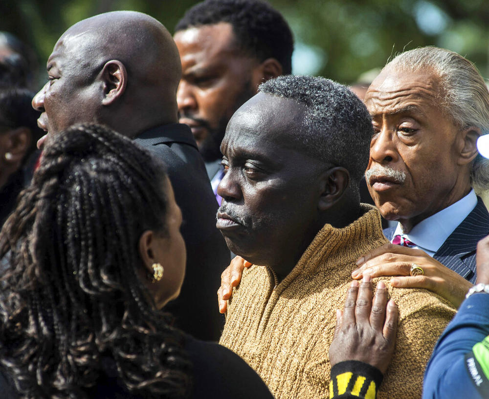 Rev. Al Sharpton, right, and Barbara Arnwine, founder of the Transformative Justice Coalition, rest their hands on Marcus Arbery's shoulder as Benjamin Crump, left, one of the Arbery family's lawyers, speaks about the slain Ahmaud Arbery outside the Glynn County courthouse, Wednesday, Nov. 10, 2021, in Brunswick, Ga. Rev. Sharpton led a prayer and spoke out against injustice during the noon break in the trial of three men charged with murder in Ahmaud Arbery's shooting death.