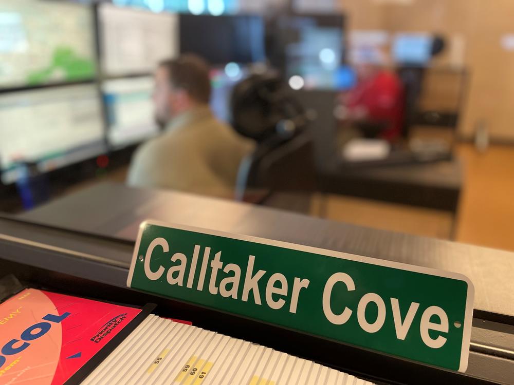 a sign reads "calltaker cove" inside the Cobb County 911 call center.