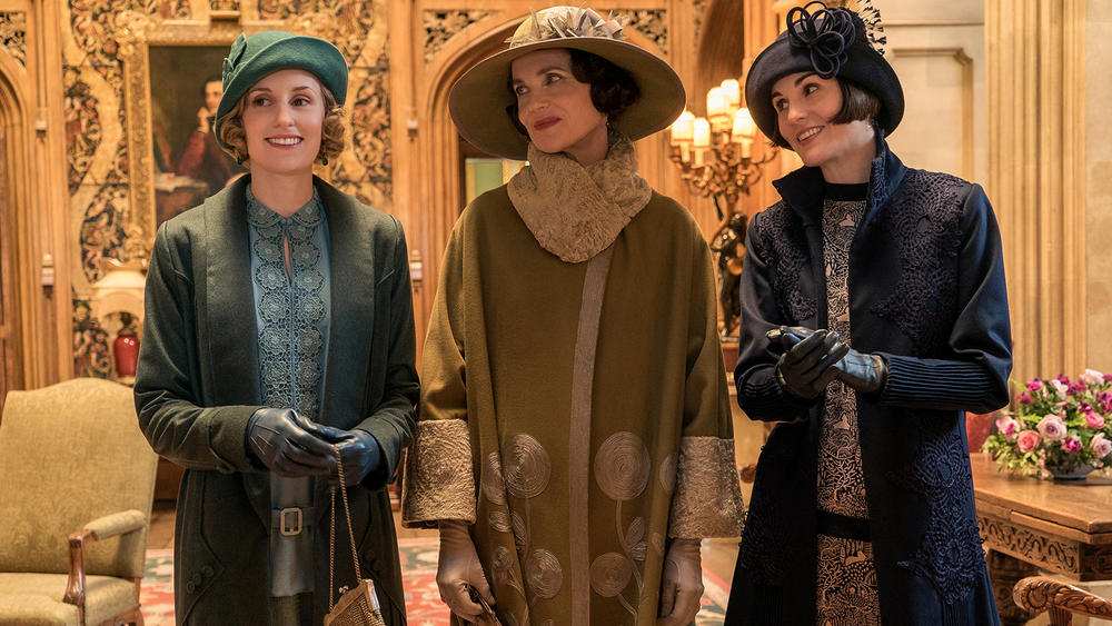 Edith, Cora and Mary Crawley smiling in coats and hats.