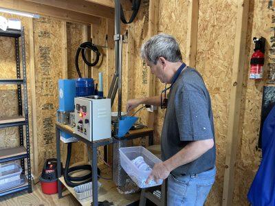 Tim Arnold of Fight Dirty Tybee feeds ground plastic into the hopper to be melted. 