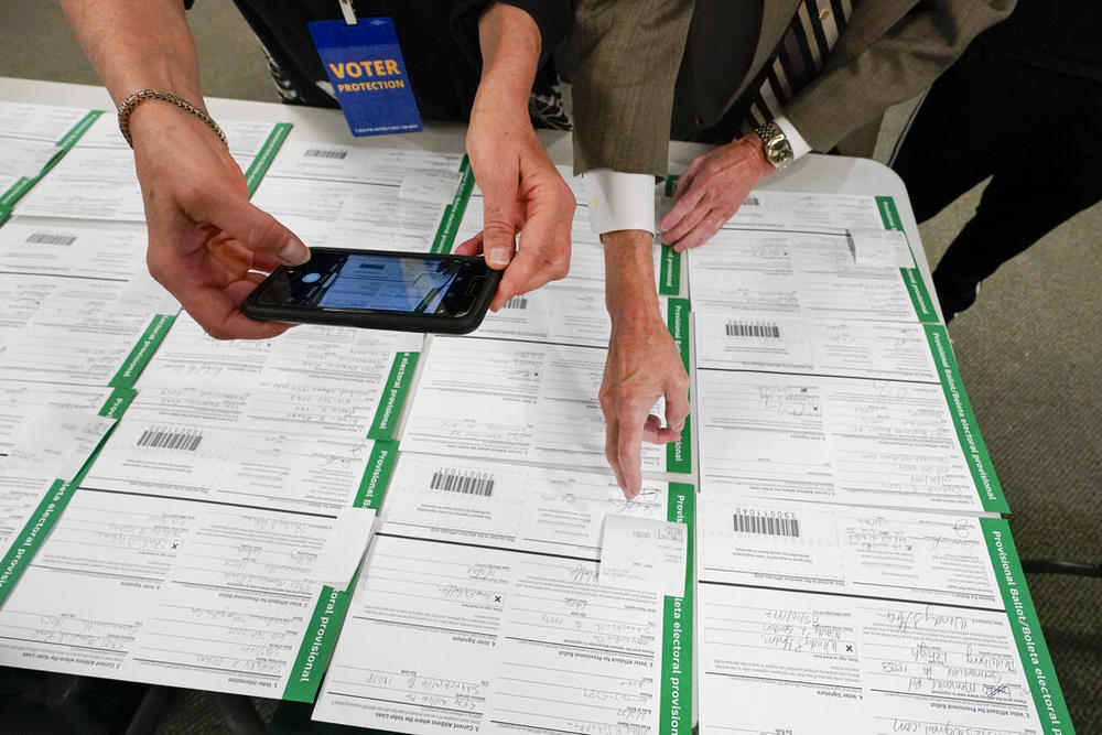 A canvas observer photographs Lehigh County provisional ballots as vote counting in the general election continues, Nov. 6, 2020, in Allentown, Pa.