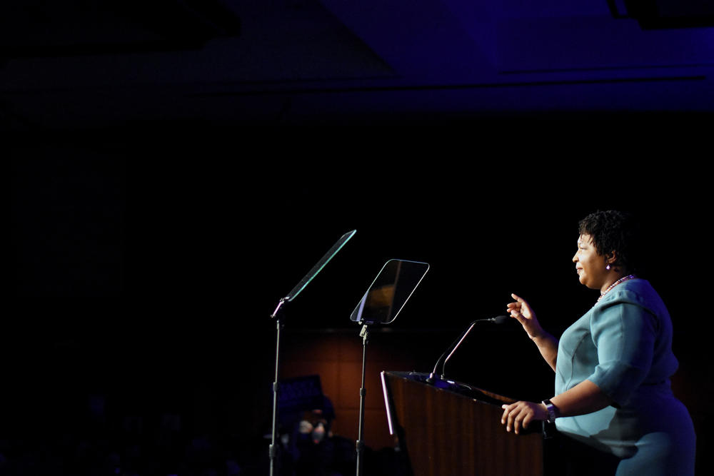 Stacey Abrams speaks from a stage to an audience.