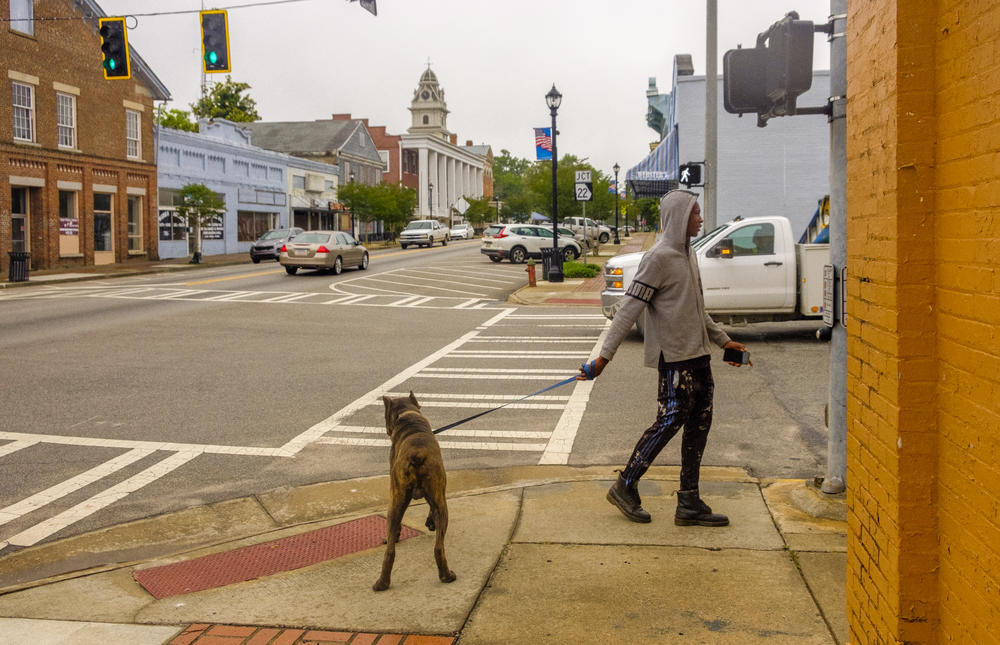 Amariel Yehudah walks his dog Draco in downtown Sparta, the Hancock County seat, in May 2020. 