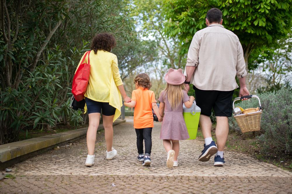 children walk with parents for a picnic