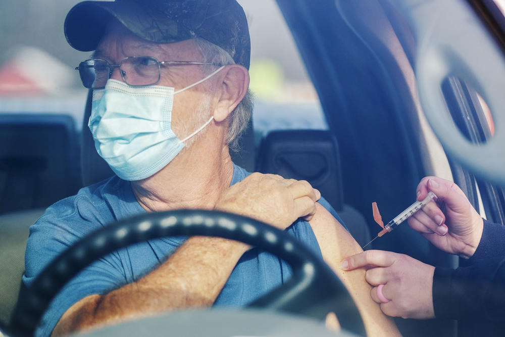 Man receiving vaccination through car window
