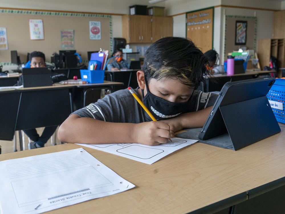 A student wears a face mask while doing work at his desk at the Post Road Elementary School, in White Plains, N.Y., in this Thursday, Oct. 1, 2020, file photo. U.S. health officials say the highly contagious delta version of the coronavirus is behind changes to mask guidelines.