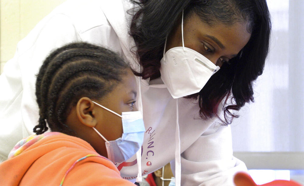 Shameika Averett, founder of Gigi's PEARLS, Inc., works with a student at Dorothy Height Elementary School on Jan. 14, 2022, in Columbus, Ga. Six years after her daughter, mother and brother were murdered in a triple homicide, Averett created the nonprofit organization to help Columbus area girls become successful women who are constructive citizens in their community — and don’t tolerate violence.