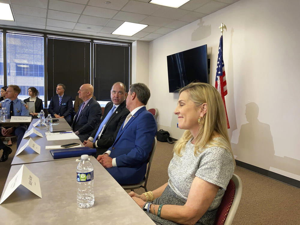 Georgia Attorney General Chris Carr speaks to Gov. Brian Kemp, second right, during an anti-gang task force meeting on Wednesday, Feb., 9, 2022, in Atlanta, as Marty Kemp, the governor's wife, looks on. Carr and Kemp are supporting moves to give Carr's office more power to prosecute gang crimes.