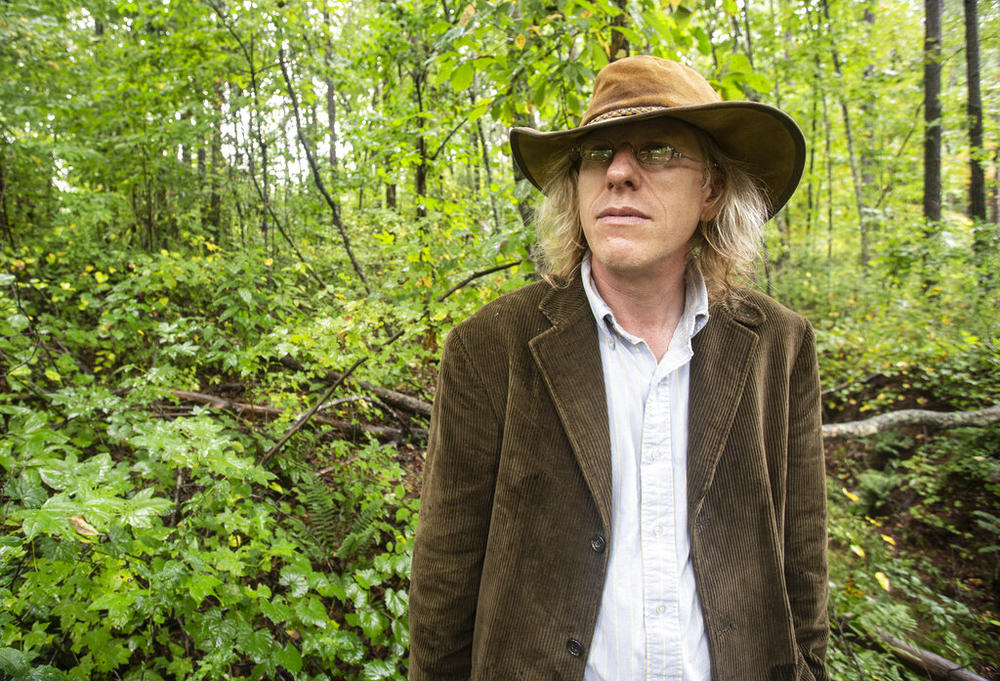 Jonathon Keats, an American conceptual artist, stands in the woods at the Serenbe community on Monday, Sept. 20, 2021, in Chattahoochee Hills, Georgia. Keats is in the process of devising a municipal clock to be located in Atlanta which would display time based on the flow rate of local rivers and waterways.
