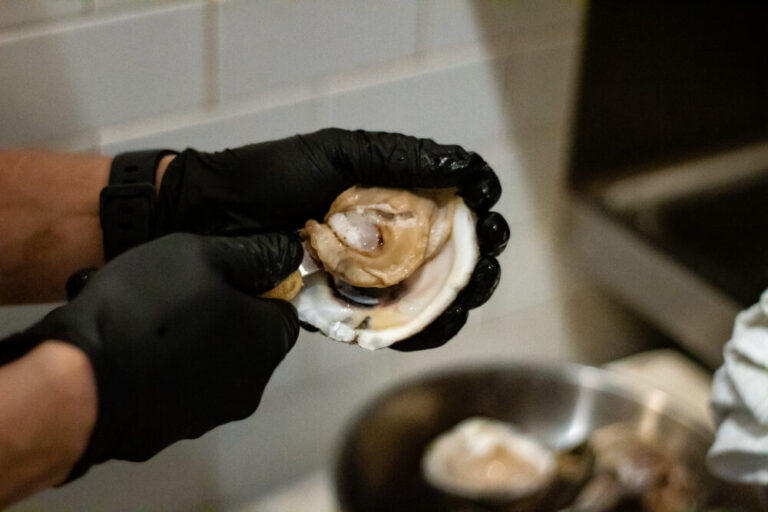 A chef at C&S Seafood in Sandy Springs shucks an oyster from Maine during the lunch rush.