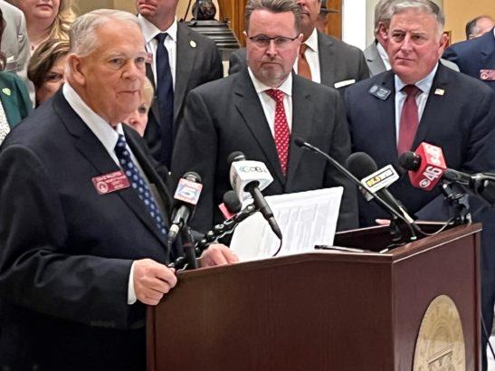 Ralston (left), with Kevin Tanner, chairman of a mental health commission, and Insurance Commissioner John King, speaking about his bill.