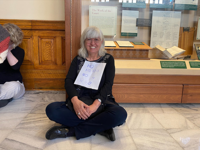 Elaine Ligorn protests HB 1013 outside of the bill's hearing in the Senate Mental Health Parity meeting. She is concerned the bill could threaten citizens' rights.