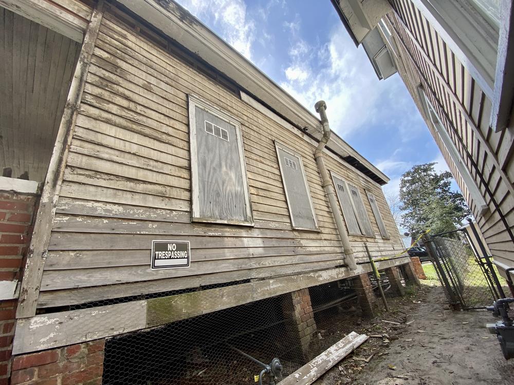 As part of their work on the pilot project house, the construction crew has removed the siding in order to restore the property's natural wood exterior.
