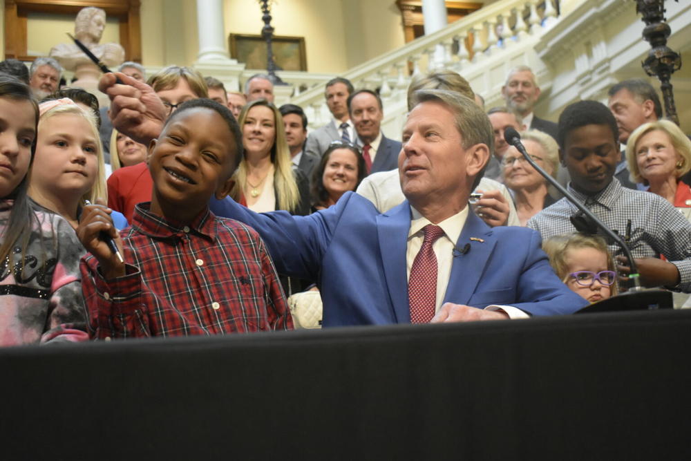 Gov. Brian Kemp hands out souvenir signing pens after signing the school mandate ban into law. Under the law, schools cannot mandate masks for Georgia’s more than 1.6 million students.