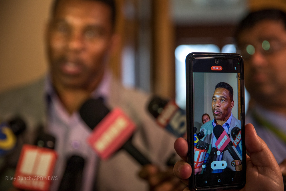 Republican Senate challenger Herschel Walker speaks to media in the state Capitol.