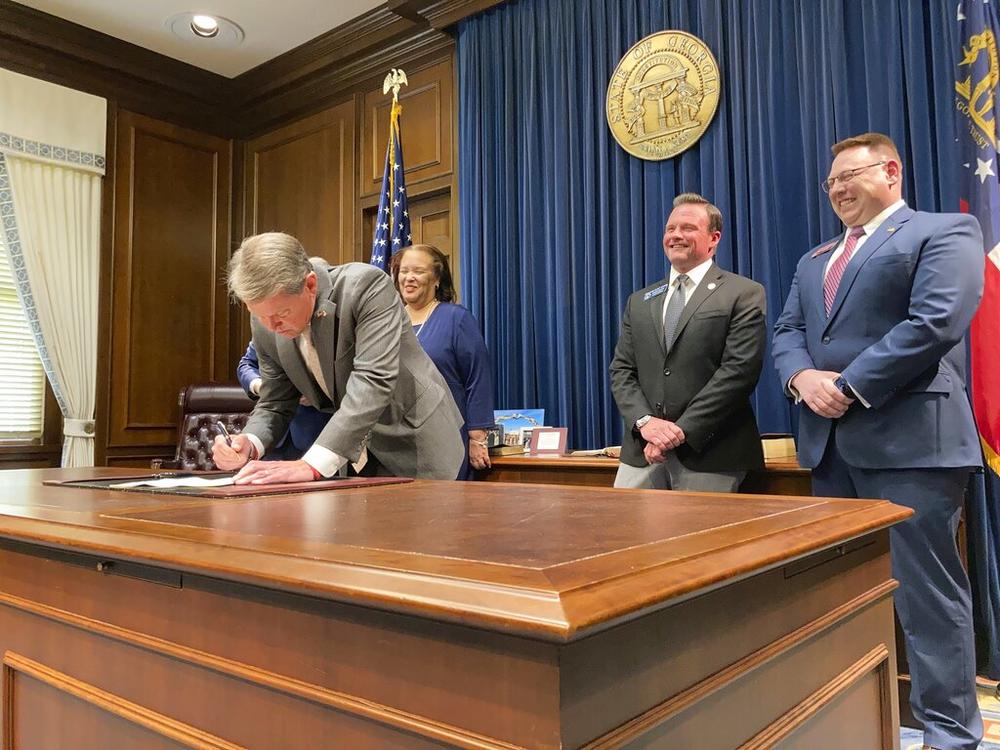 Georgia Gov. Brian Kemp signs a bill to give state income refunds of more than $1.1 billion on Wednesday, March 23, 2022, at the Georgia capitol in Atlanta. The measure gives refunds of $250 to $500 to people who filed tax returns for 2020 and 2021. 