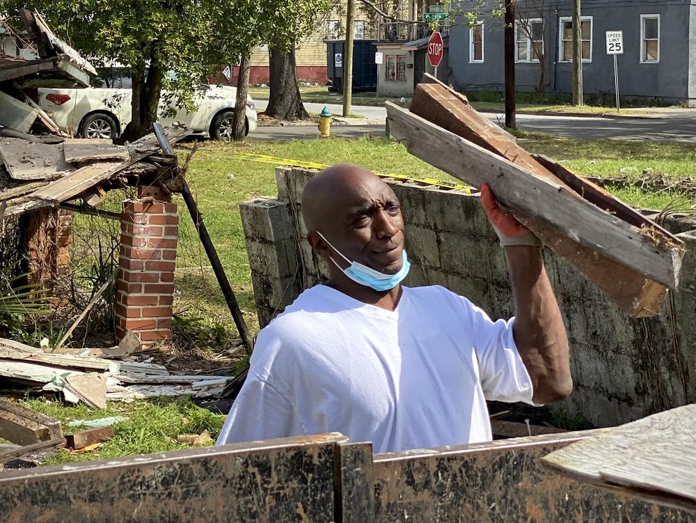Project supervisor Novell Bryant removes debris from the backyard into a pickup truck trailer.