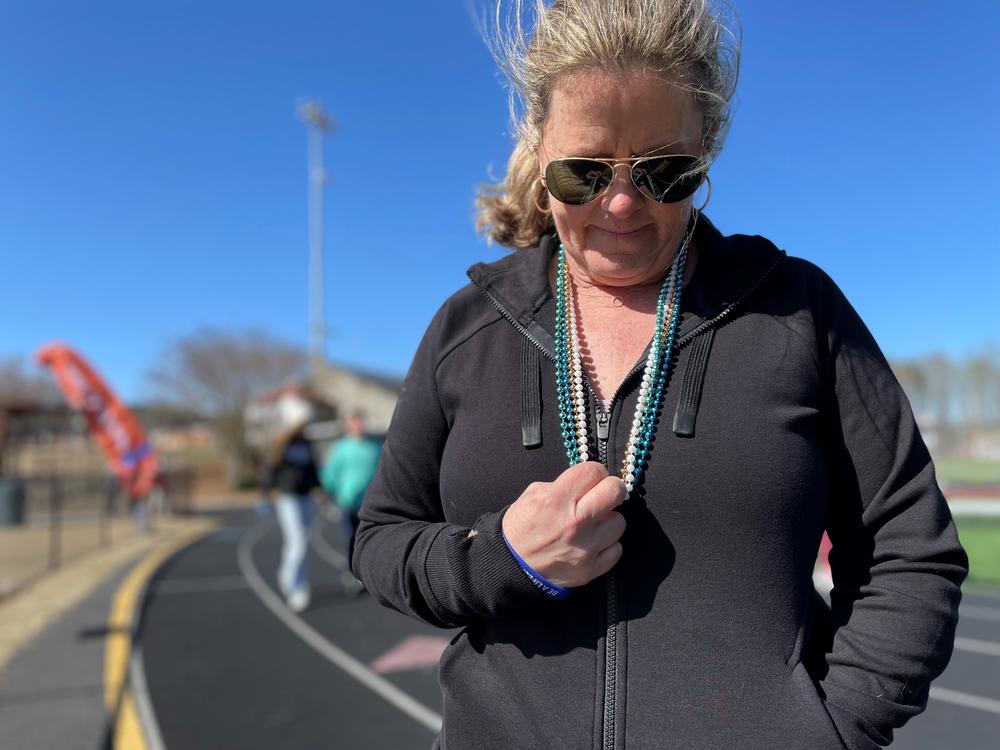 Mary Norris holds the strands of beads around her neck