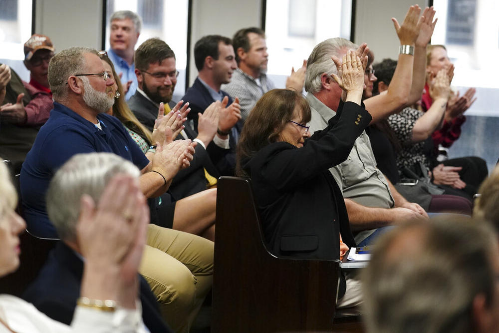 People applaud U.S. Rep. Marjorie Taylor Greene inside court, Friday, April 22, 2022, in Atlanta. Rep. Greene is appearing at a hearing Friday in Atlanta in a challenge filed by voters who say she shouldn't be allowed to seek reelection because she helped facilitate the attack on the Capitol that disrupted certification of Joe Biden's presidential victory.