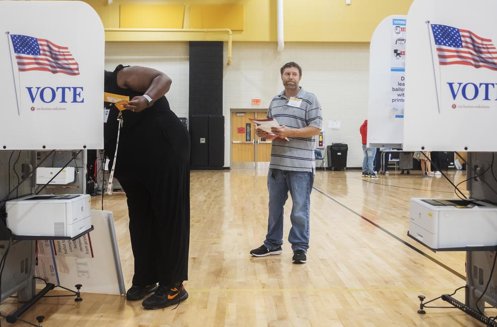 Republican poll watcher Brad Emerton examined each voting machine, making sure vote counts were at zero, as officials set up the East Macon 3 voting precinct Tuesday morning.