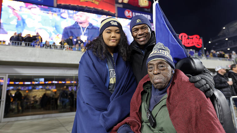 A young woman with father and grandfather in a wheelchair.