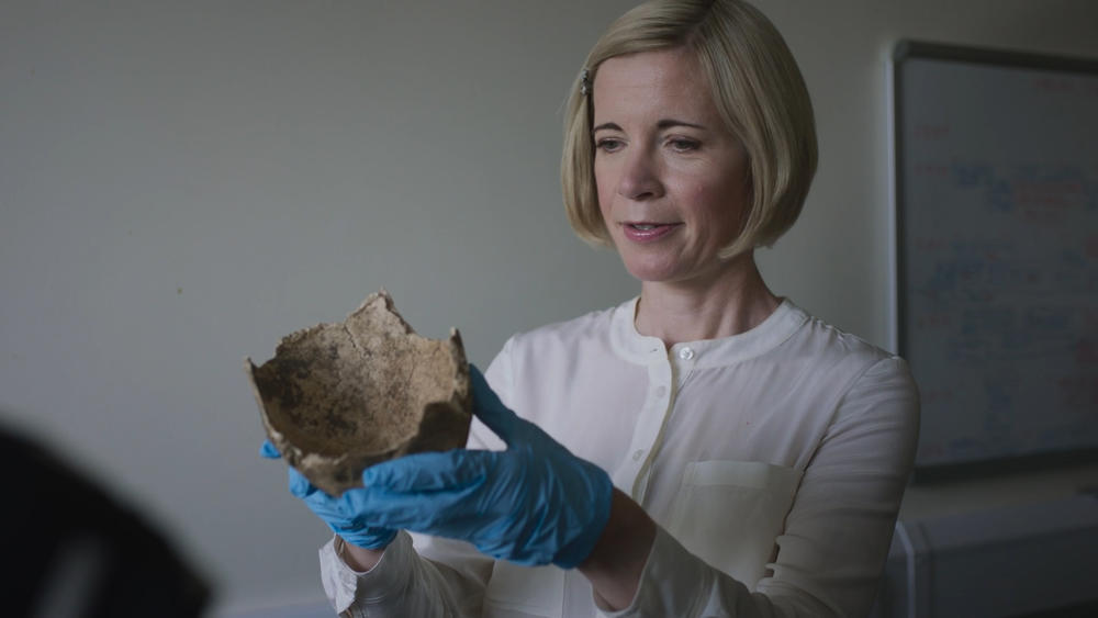 Lucy holds a skull from a set of human remains sent to Turi King at Leicester University.