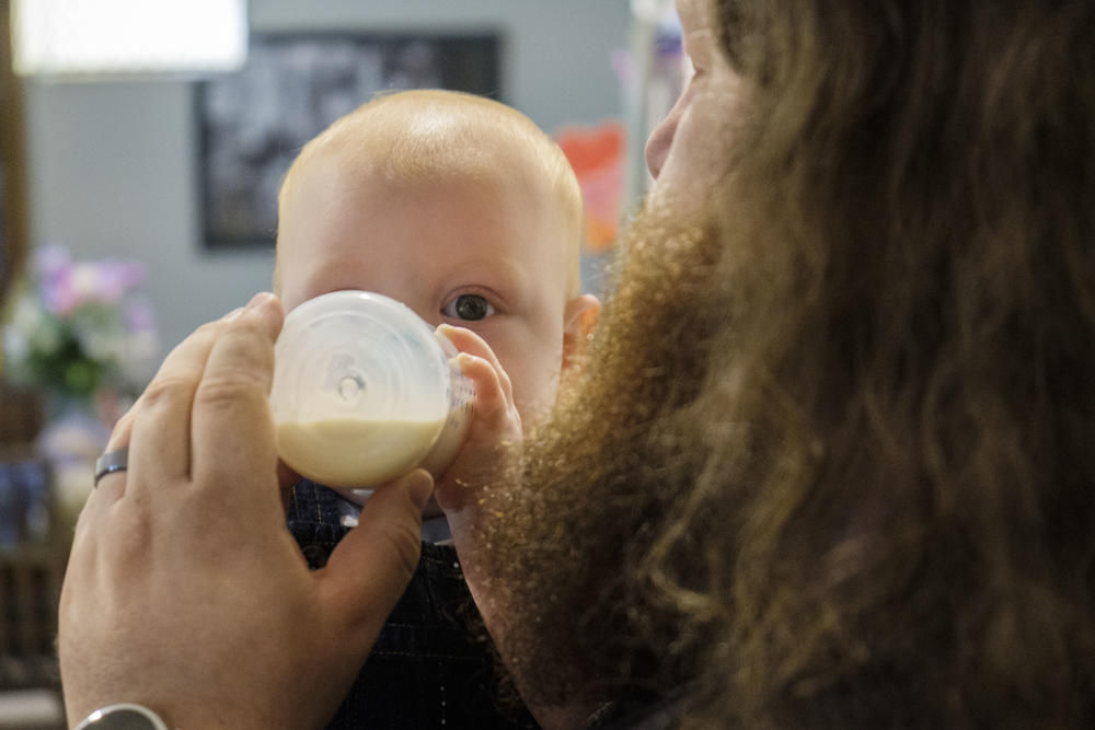 Wesley Reimer feeds his son Marshall from a bottle in their Macon home. Reimer partially blames the current baby formula shortage on panicked shoppers stockpiling formula and on profiteers selling formula online.