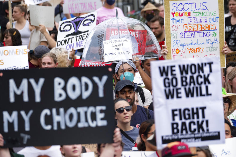 A crowd of people holding signs in protest of the Supreme Court decision to overturn Roe v. Wade