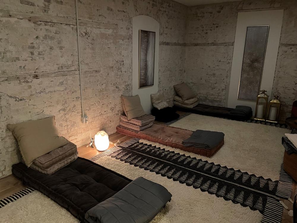 A dimly lit room with cushions and pillows on the floor