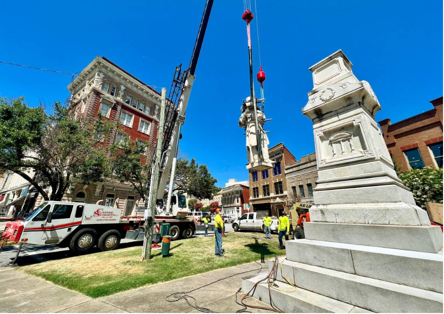 Crews lower the Confederate monument on Cotton Avenue while removing it Wednesday morning. The monument will be relocated to Whittle Park in front of Rose Hill Cemetery. 